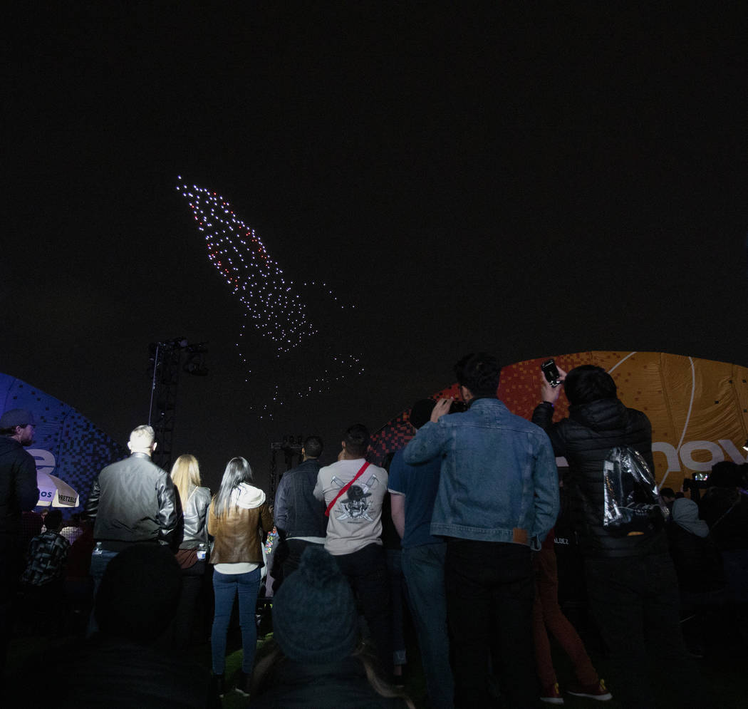 Festival-goers look up at The Expanse Drone Space Opera performance on Saturday, Dec. 7, 2019, ...