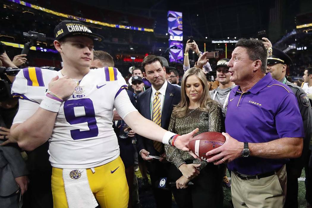 LSU quarterback Joe Burrow and LSU head coach Ed Orgeron celebrate after the Southeastern Confe ...