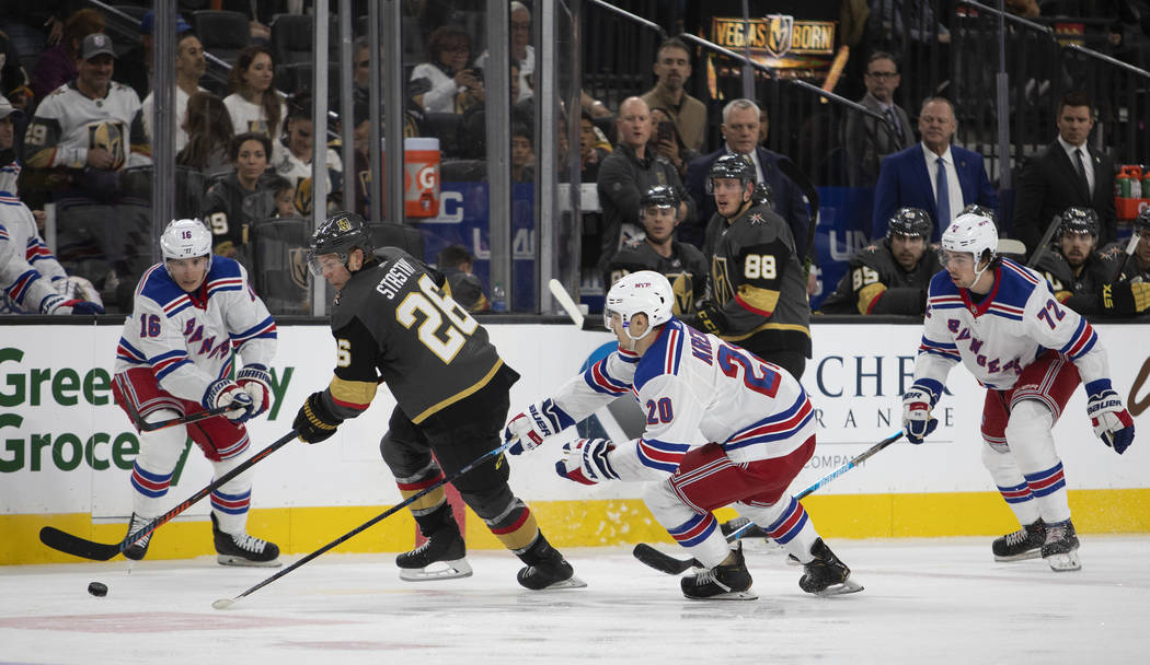 Golden Knights center Paul Stastny (26) goes for the puck alongside New York Rangers center Rya ...