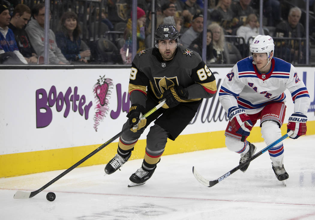 Golden Knights right wing Alex Tuch (89) looks to pass the puck next to New York Rangers defens ...