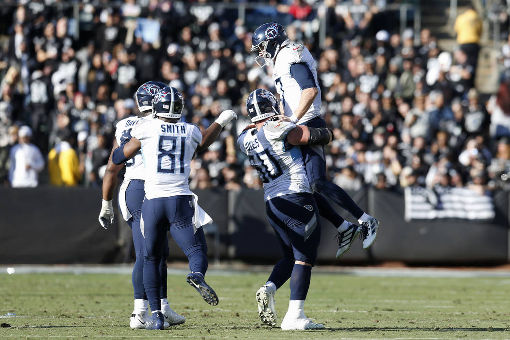 Tennessee Titans quarterback Ryan Tannehill, top, celebrates with teammates after throwing a to ...