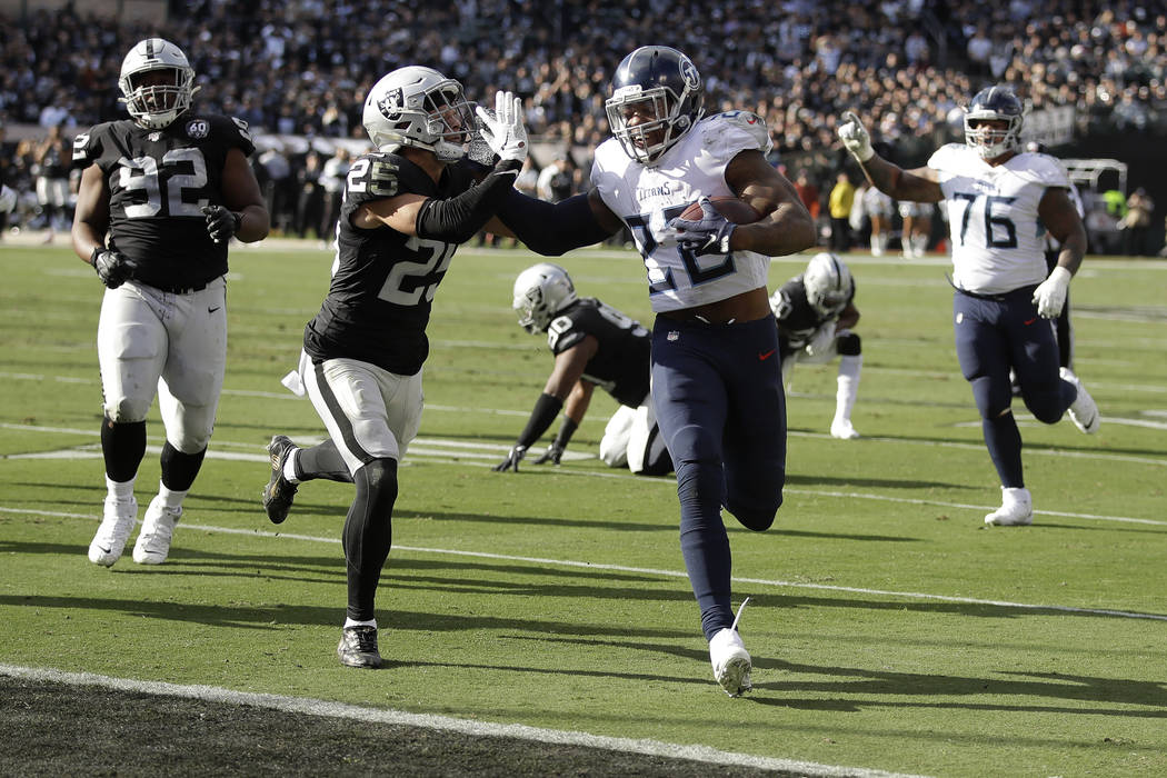 Tennessee Titans running back Derrick Henry (22) scores past Oakland Raiders free safety Erik H ...