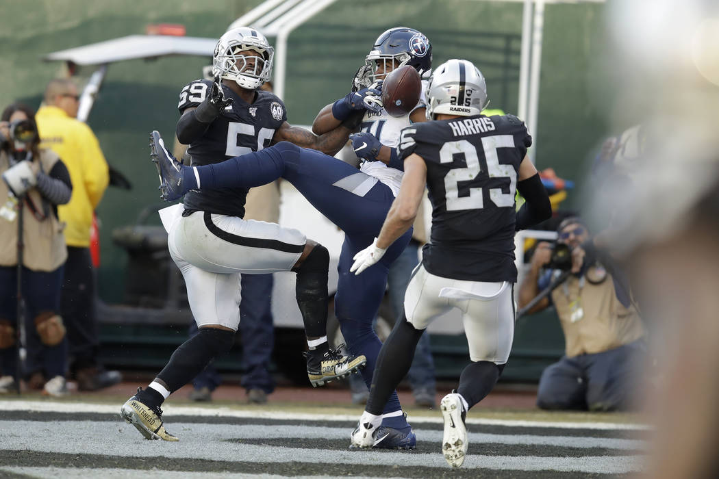Tennessee Titans tight end Jonnu Smith, center, catches a touchdown pass between Oakland Raider ...