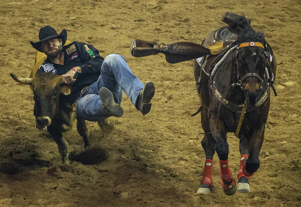 Bridger Chambers of Stevensville, Mont., leaps onto a steer for a time of 3.60 seconds and firs ...