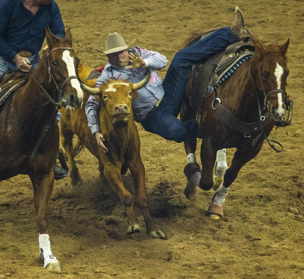 Hunter Cure of Holliday, Texas, leaps onto a steer in Steer Wrestling during the fourth go roun ...