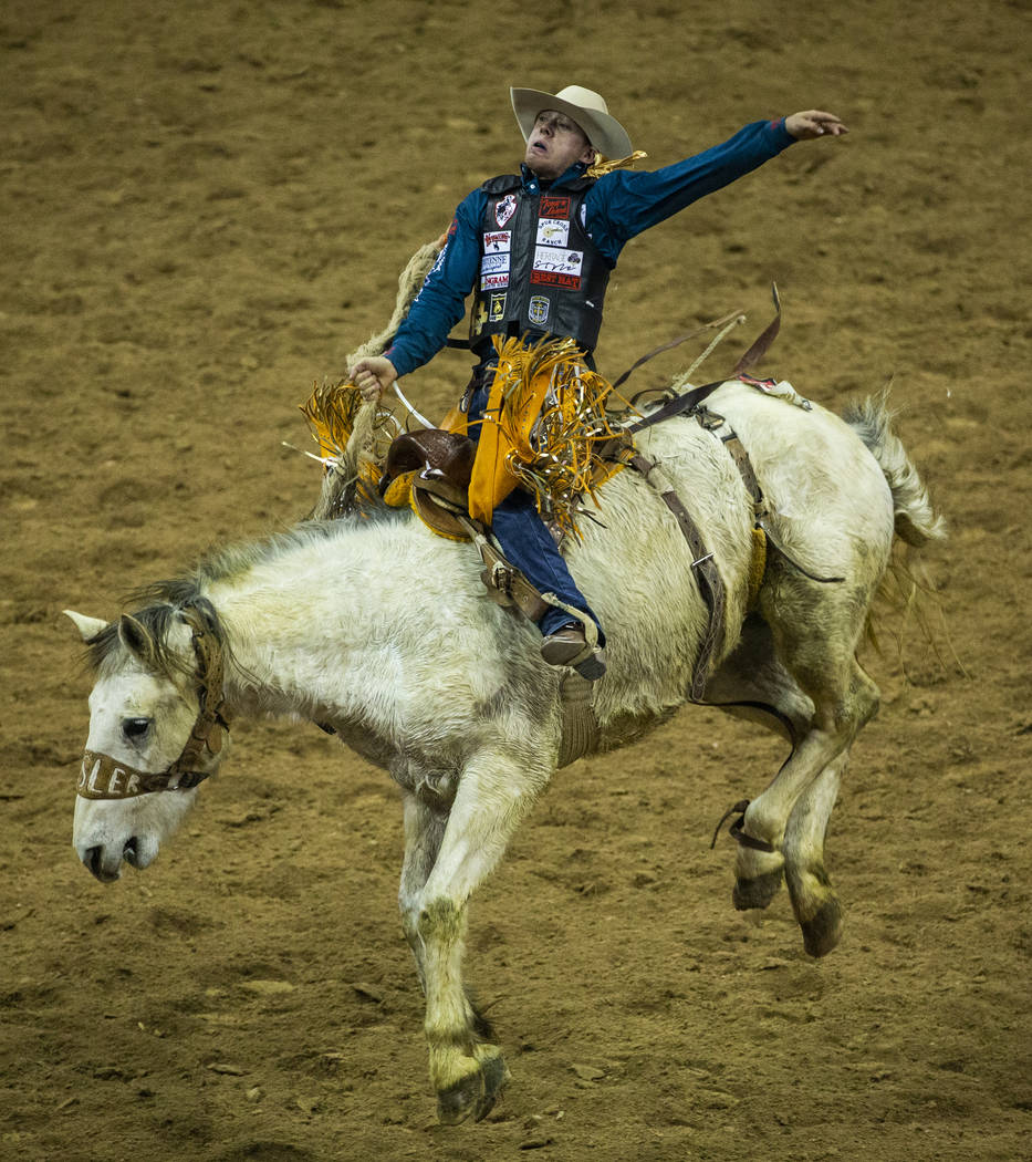 Brody Cress of Hillsdale, Wyo., catches some air atop Artificial Colors in Saddle Bronc Riding ...