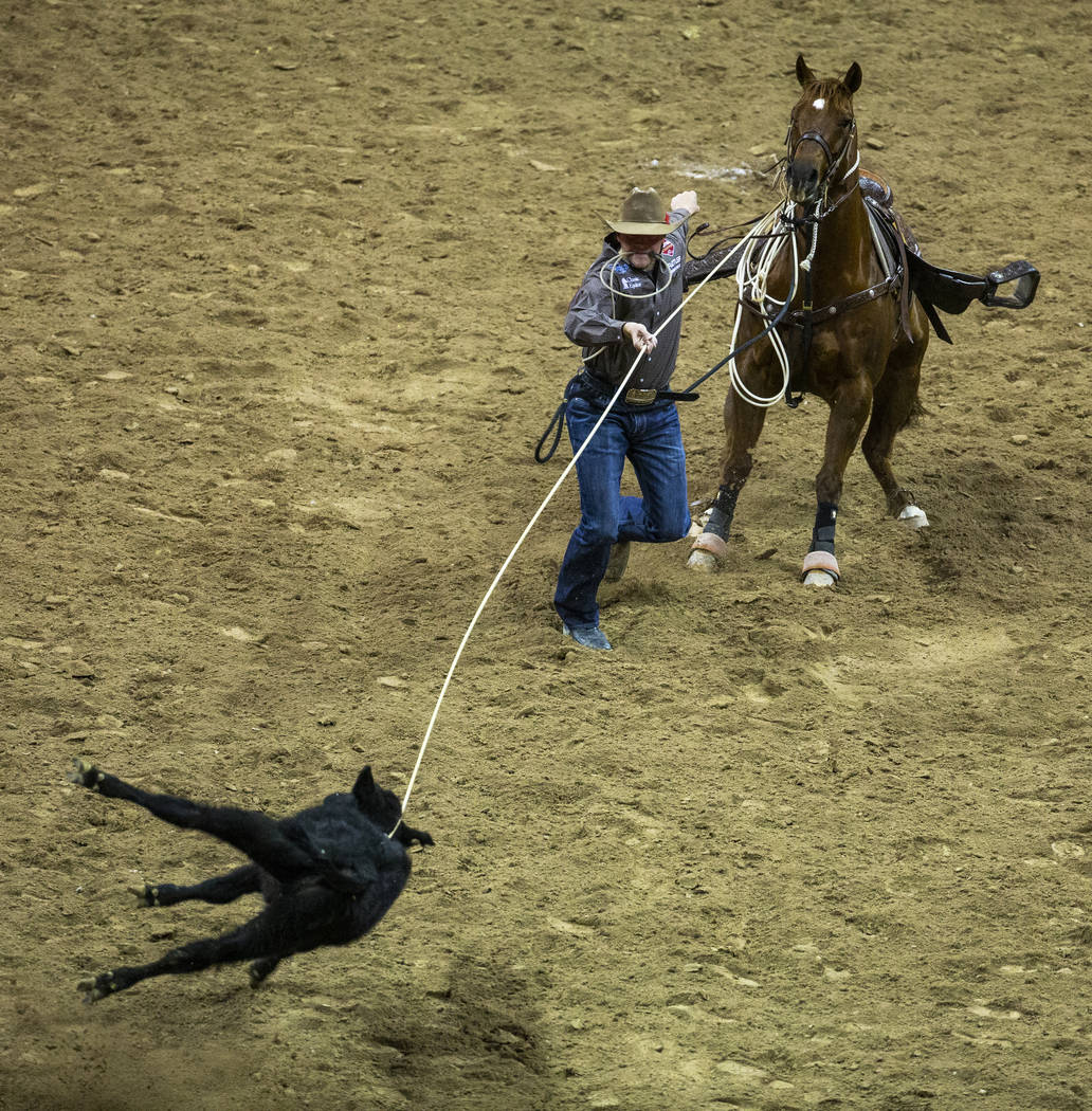 Cooper Martin of Alma, Kan., works to his calf in Tie-Down Roping during the fourth go round of ...
