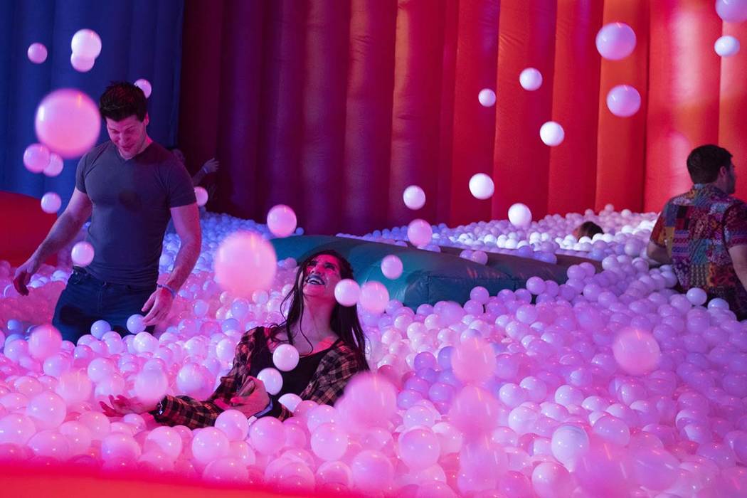 Rosa Garcia of Las Vegas, center, throws plastic balls into the air in the ball pit at Intersec ...