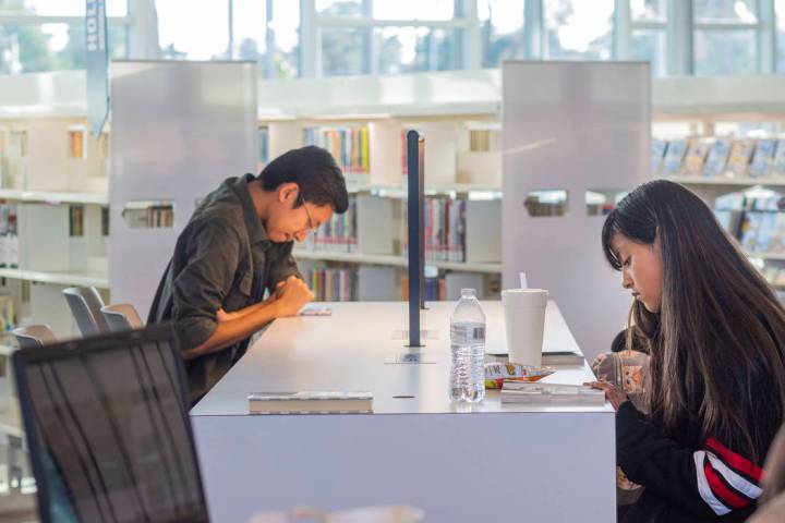 John Ollado, 20, left, and Heidi, 12, sit in the East Las Vegas Library in Las Vegas on Tuesday ...