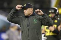 Oregon offensive coordinator Marcus Arroyo watches his team during warmups before their NCAA co ...