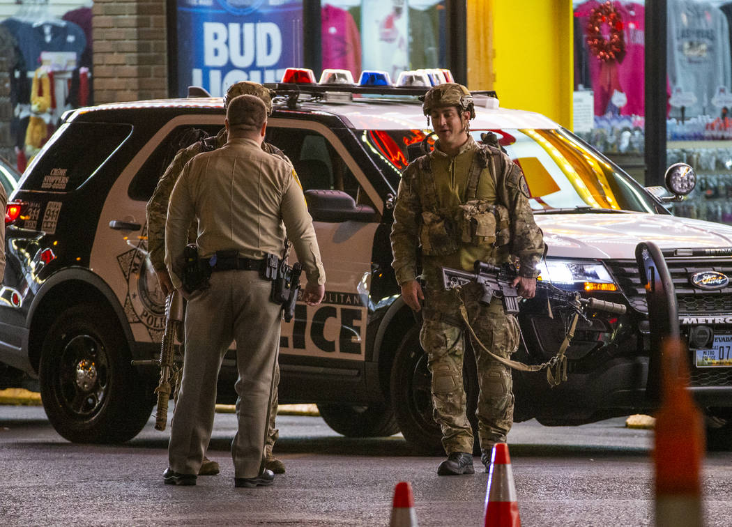 Las Vegas police gather in the parking lot as they work a barricade situation of a woman with a ...