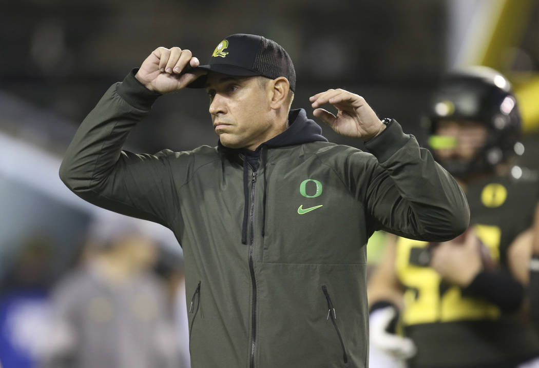 Oregon offensive coordinator Marcus Arroyo watches his team during warmups before their NCAA co ...