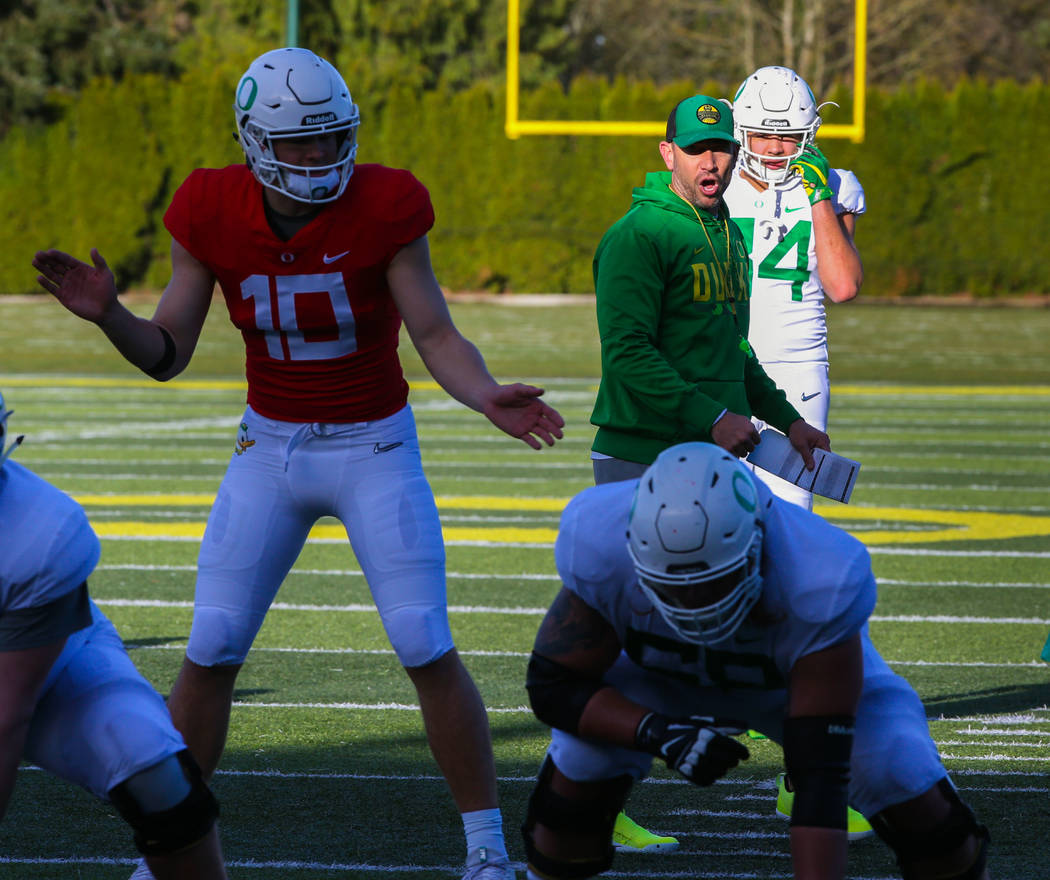 Oregon Offensive Coordinator Marcus Arroyo, center, works with the quarterbacks and the offense ...
