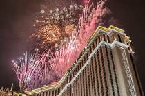 New Year's Eve party goers watch the fireworks outside the Venetian hotel-casino on the Strip o ...