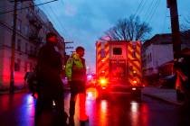 First responders and law enforcement personnel stand near the scene following a shooting, Tuesd ...