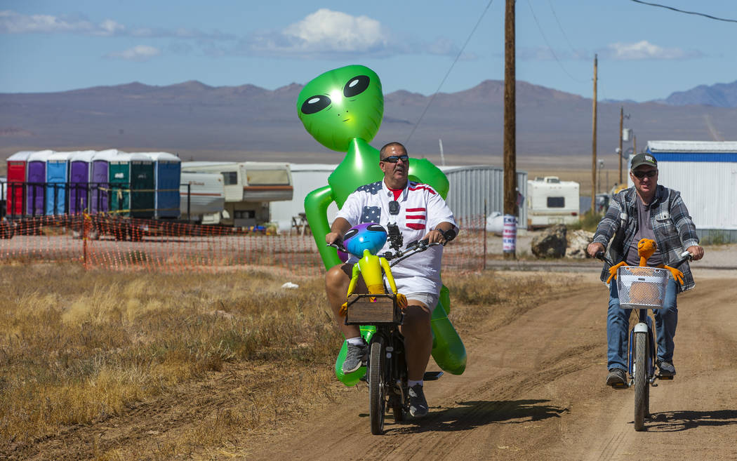 Eric Harvey, left, and Jason Webster of Orange County cruise around the parking area with alien ...