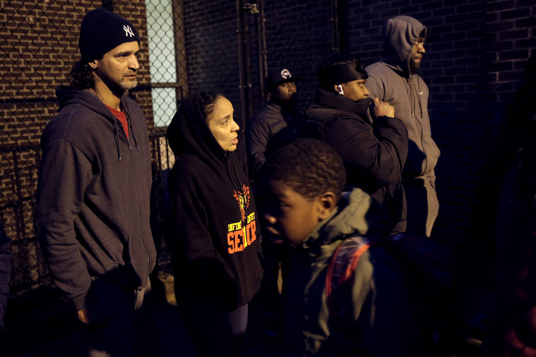 Anxious families wait for their children to exit Whitney M. Young Jr. Community School after th ...