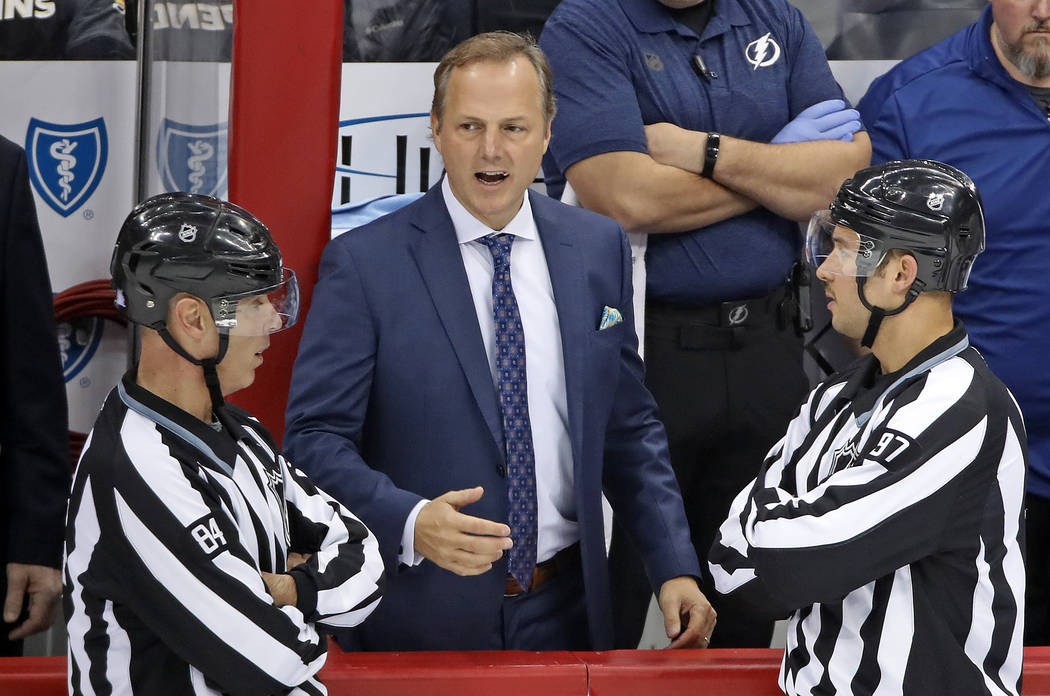 Tampa Bay Lightning coach Jon Cooper, center, talks with linesmen Tony Sericolo (84) and Kory N ...
