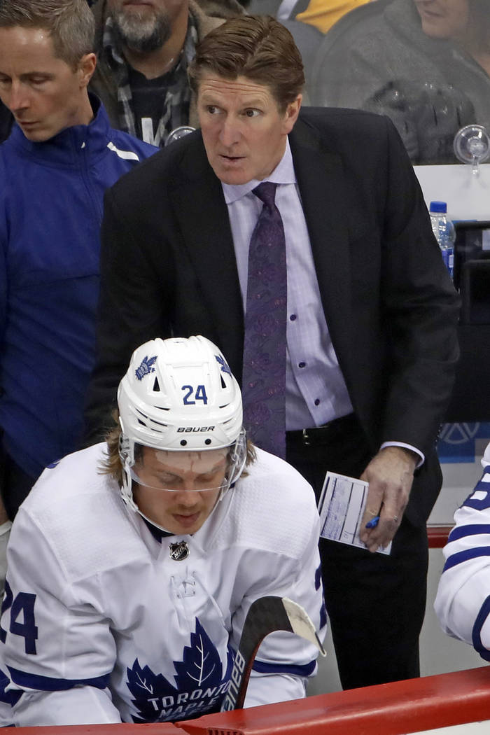Toronto Maple Leafs head coach Mike Babcock stands behind Kasperi Kapanen (24) during the first ...