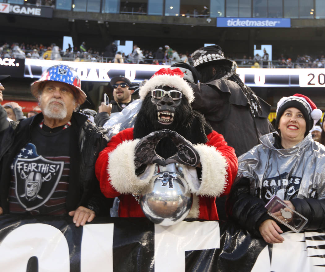 The fans in the Black Hole pose before the start of an NFL game between the Oakland Raiders and ...