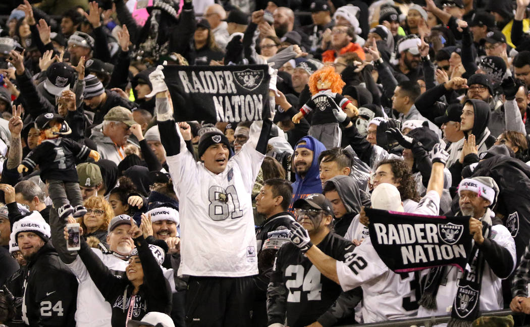 Oakland Raiders fans hold up dolls and towels during the first half of an NFL game against the ...