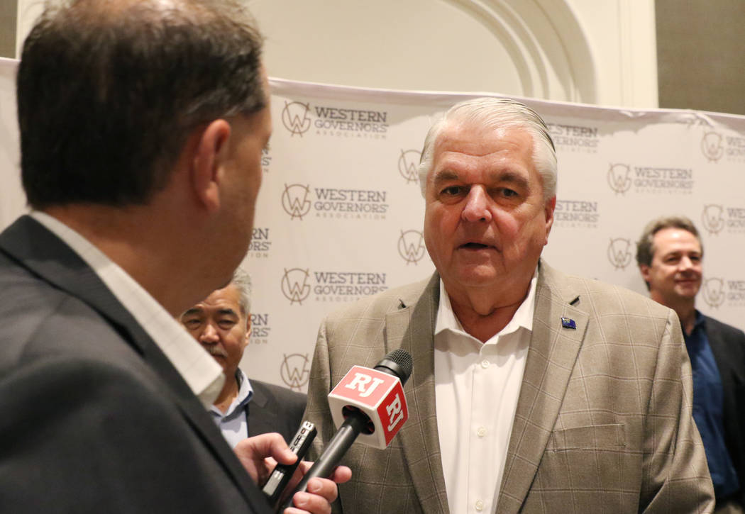Gov. Steve Sisolak answers reporters questions as he arrives at the Four Seasons hotel to atten ...