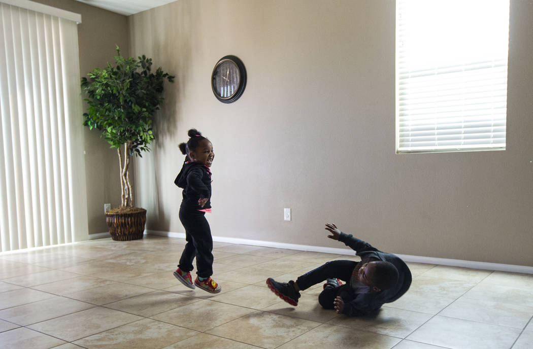 Christine Modica, 3, left, jumps around the open space in the living room with her brother, Noe ...