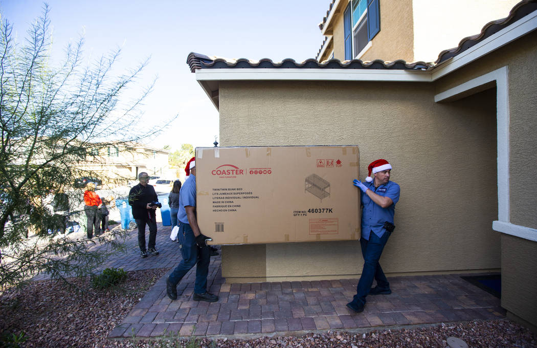 Employees from Walker Furniture deliver and set up a truckload of furnishings as part of their ...