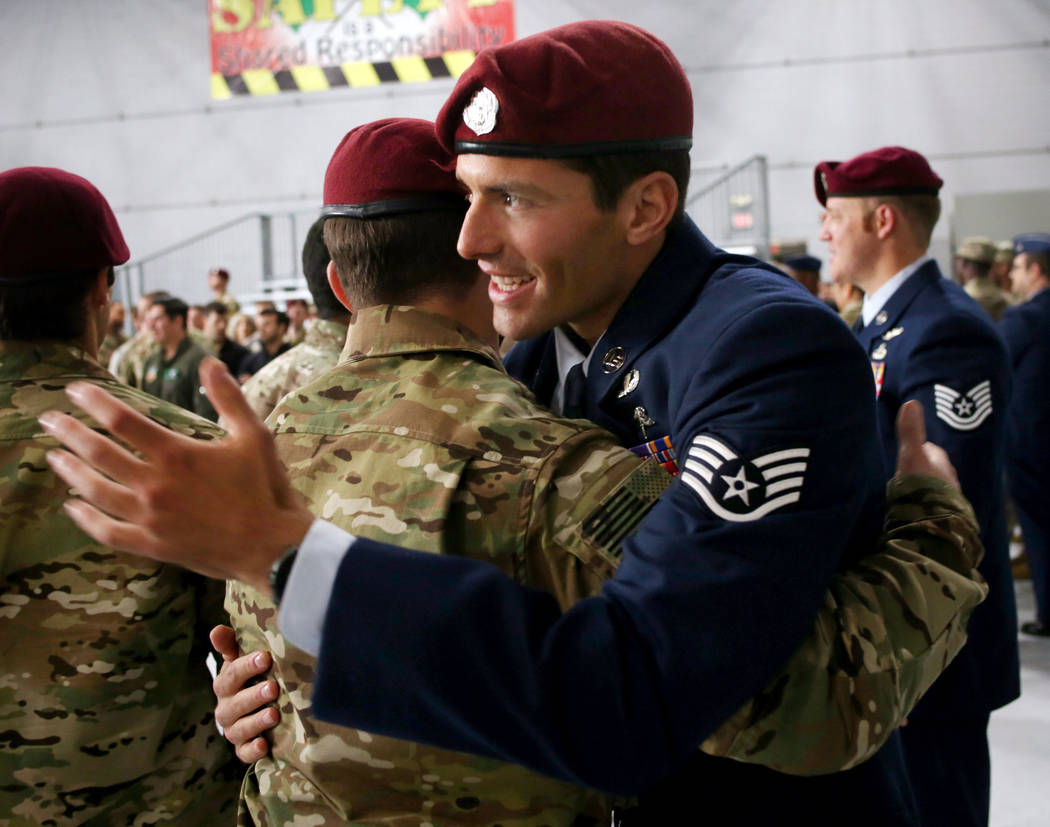 Staff Sgt. Daniel Swensen, right, hugs a member of the military after a ceremony awarding the S ...