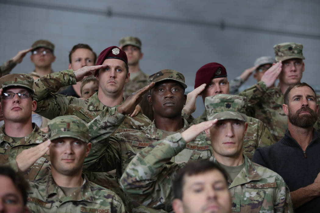 Members of the military salute during a ceremony awarding the Purple Heart and Silver Star Meda ...