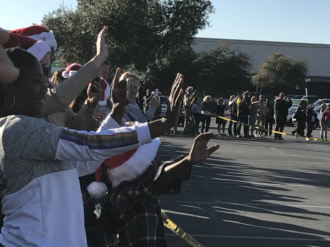 Children and their families wave to Santa Claus during a "Santa Cops" event on Saturday, Dec. 1 ...