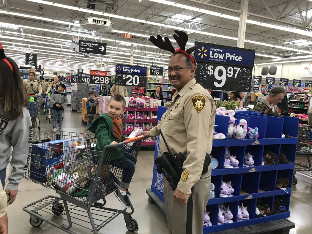 Metropolitan Police Department officer Ed Serrano pushes 3-year-old Justus in a shopping cart d ...