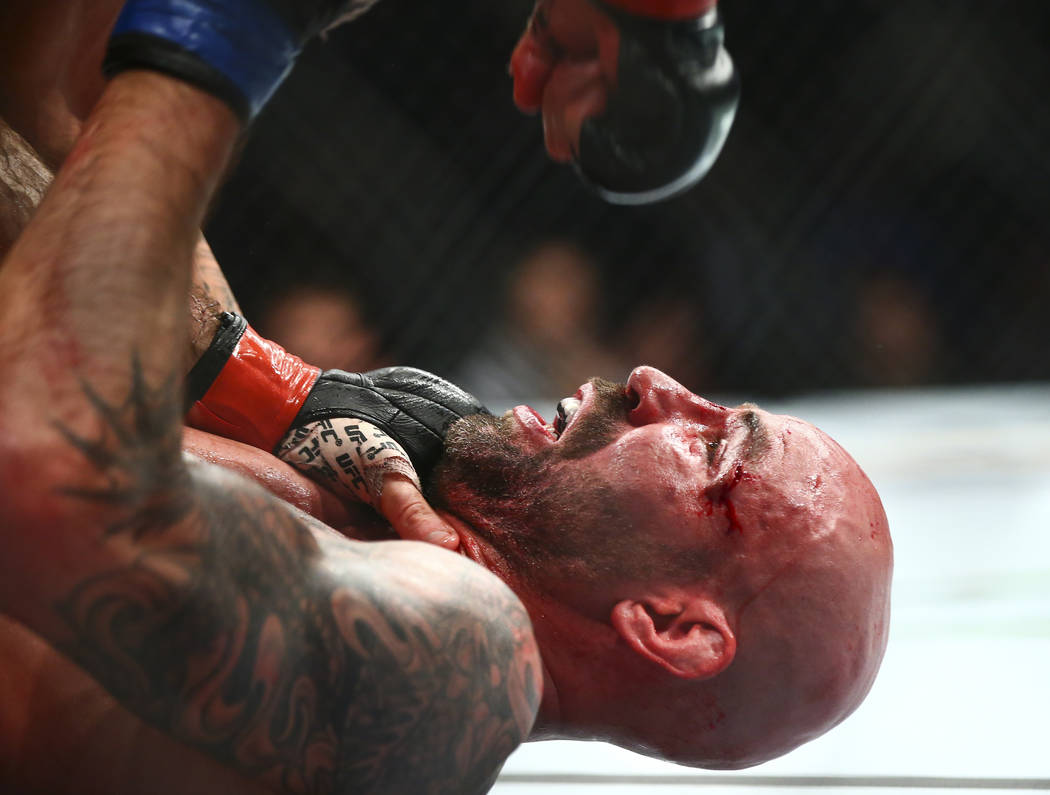 Ben Saunders takes a hit from Matt Brown during their welterweight bout in UFC 245 at T-Mobile ...