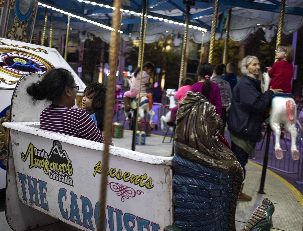 Pearl Viliamu, left, holds her son, Daxson, 2, on the carousel at Henderson's annual WinterFest ...