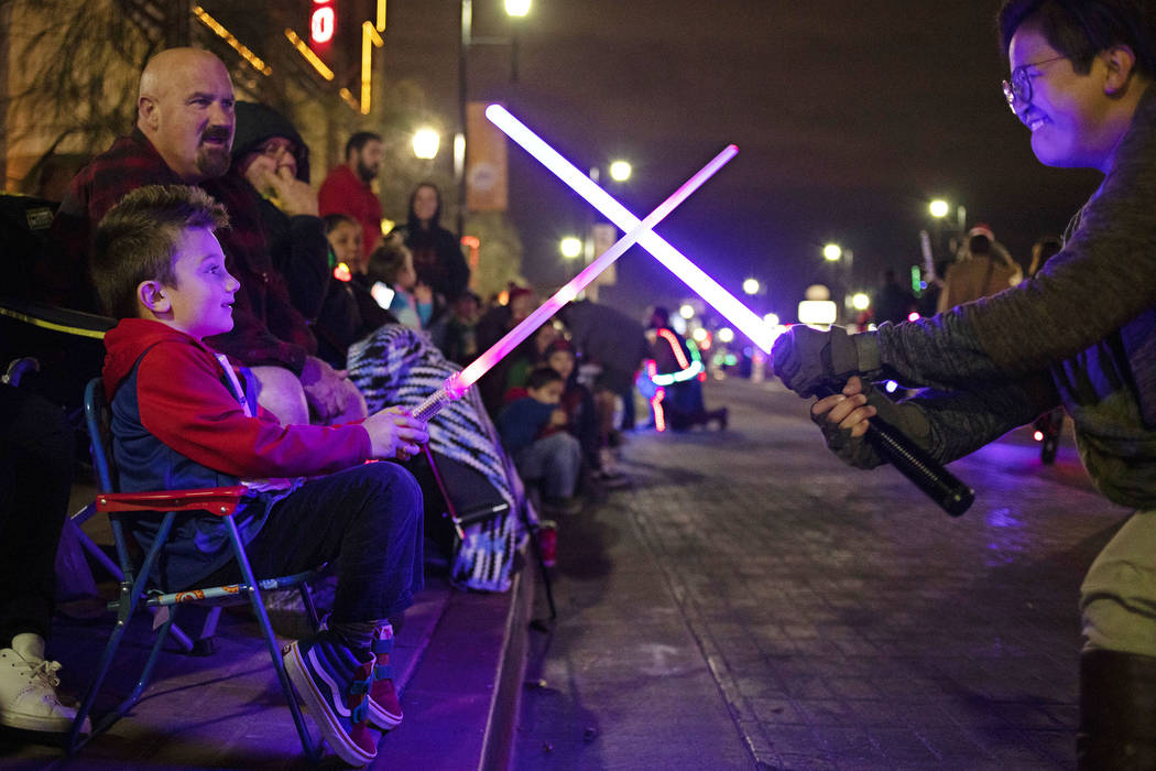 Logan Rush, 5, left, crosses light sabers with a member of Las Vegas Star Wars Clubs during the ...