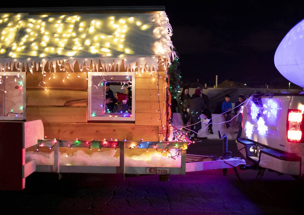 Rooftop Realty's float passes by as spectators sit along the road blocks at Henderson's annual ...