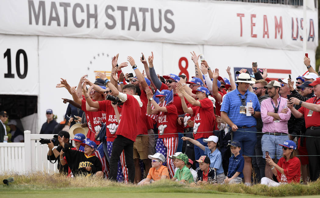 Fans of the U.S. team celebrate at the 16th hole after U.S. team player and captain Tiger Woods ...