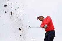 Debris flies as U.S. team player and captain Tiger Woods plays a shot on the 10th raiway in his ...