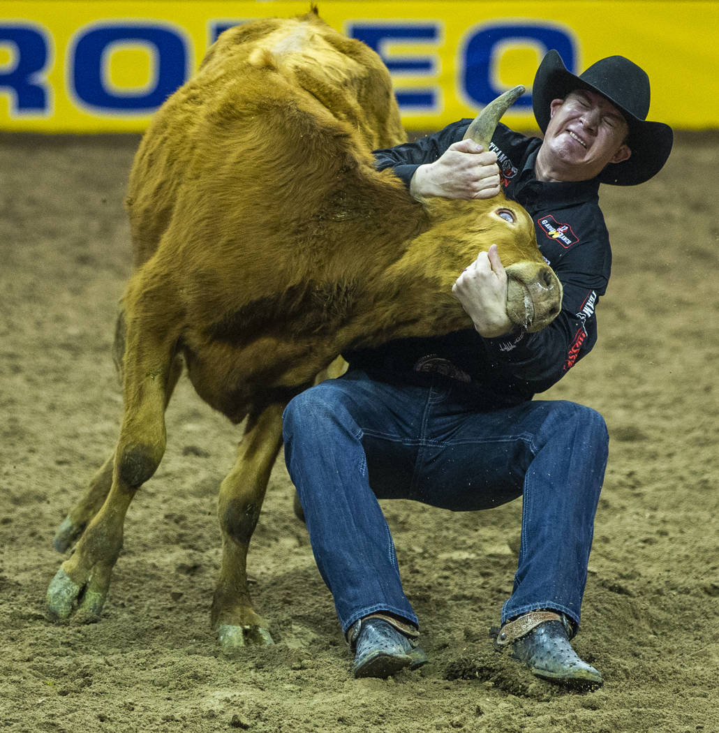 Ty Erickson of Helena, Mont., grabs the horns while bringing down a steer in Steer Wrestling du ...