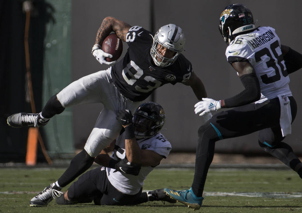 Oakland Raiders tight end Darren Waller (83) fights for extra yardage with Jacksonville Jaguars ...