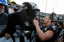 Oakland Raiders quarterback Derek Carr (4) is met by Gorilla Rilla in "The Black Hole" at the e ...