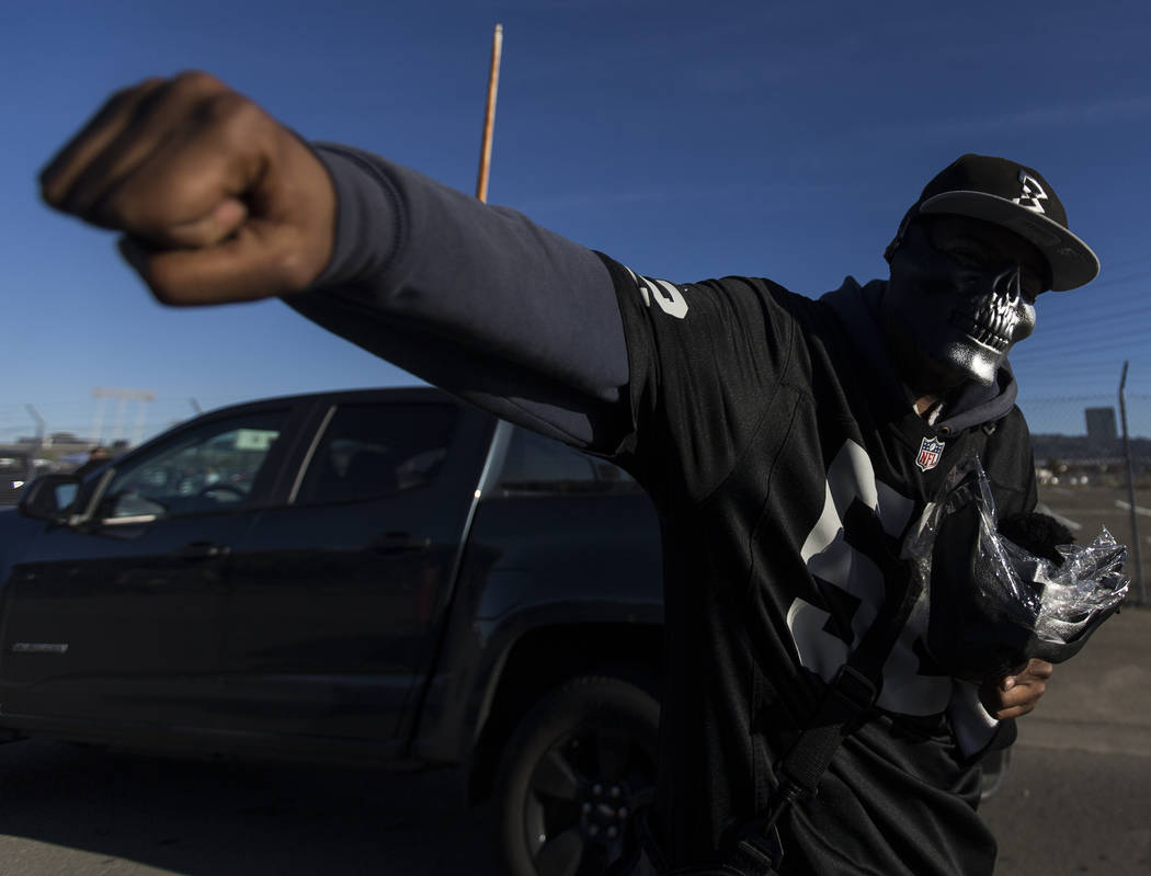 Vendors sell masks to passing cars outside the Oakland Coliseum before the start of an NFL foot ...