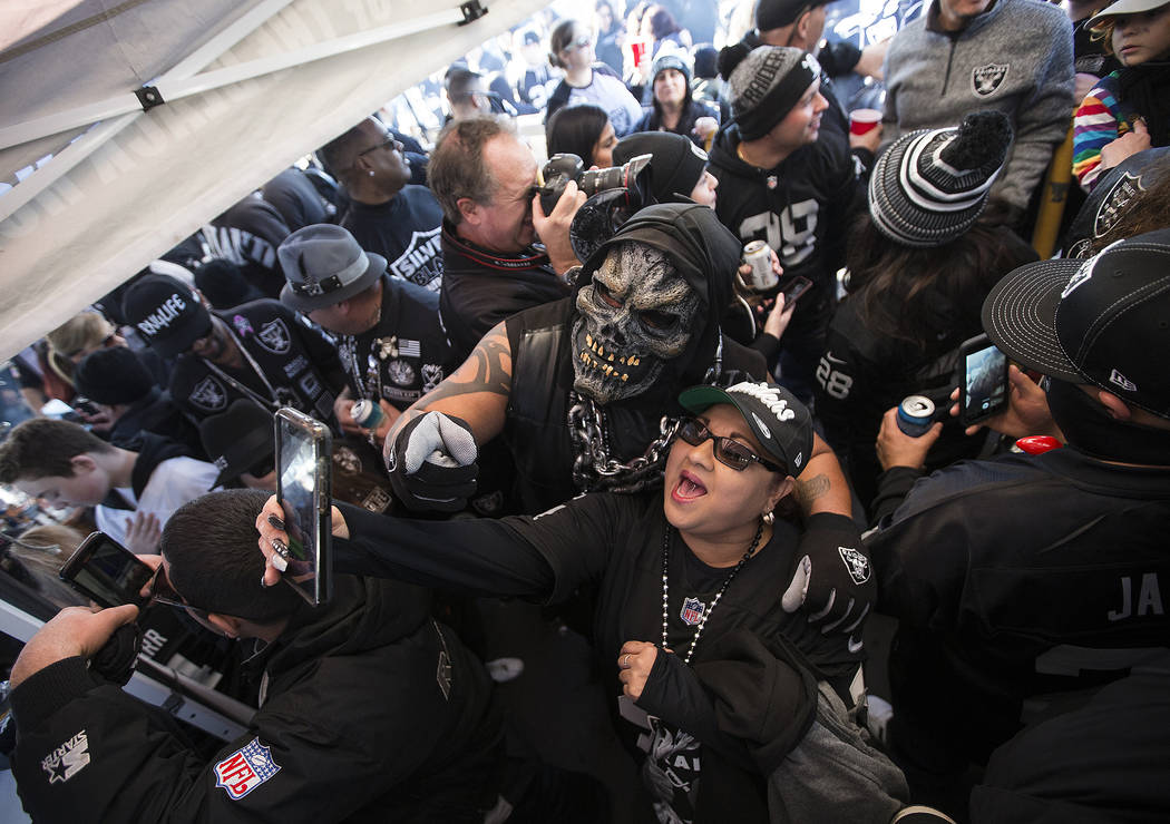 Fans tailgate outside the Oakland Coliseum before the start of an NFL football game between the ...