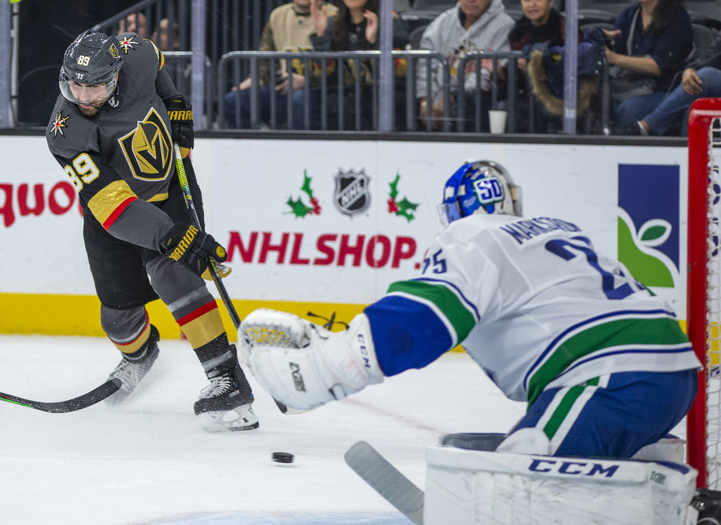 Vegas Golden Knights right wing Alex Tuch (89) shoots towards the net defended by Vancouver Can ...