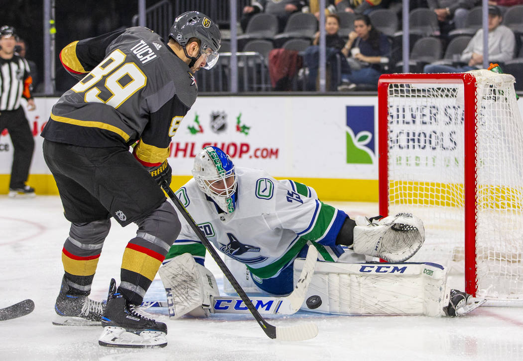 Vegas Golden Knights right wing Alex Tuch (89, left) takes a shot at the net on Vancouver Canuc ...