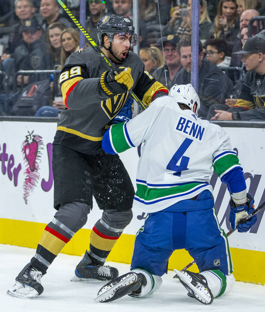 Vegas Golden Knights right wing Alex Tuch (89, left) tangles with Vancouver Canucks defenseman ...