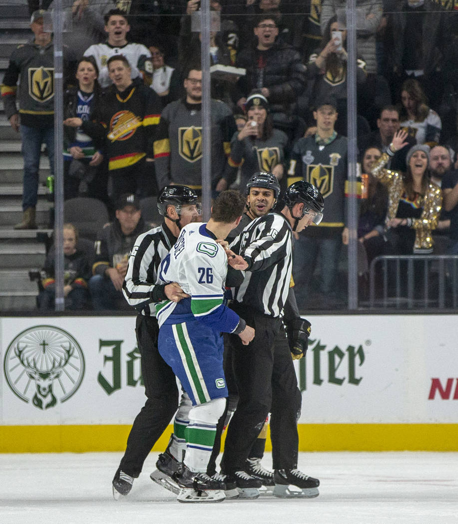Vancouver Canucks left wing Antoine Roussel (26, front) and Vegas Golden Knights right wing Rya ...
