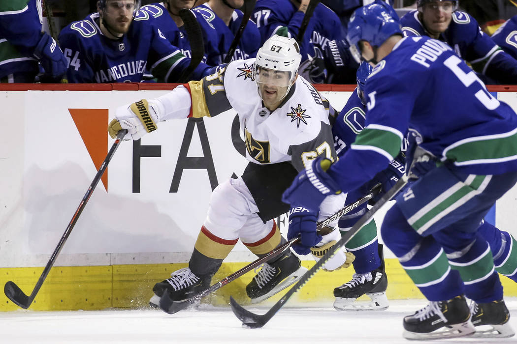 Vegas Golden Knights' Max Pacioretty (67) fights for the puck against Vancouver Canucks' Derric ...