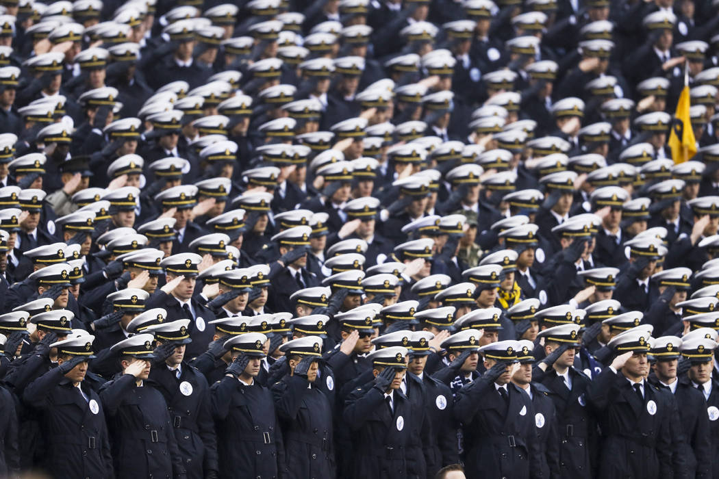 Navy midshipmen salute ahead of an NCAA college football game against Army, Saturday, Dec. 14, ...