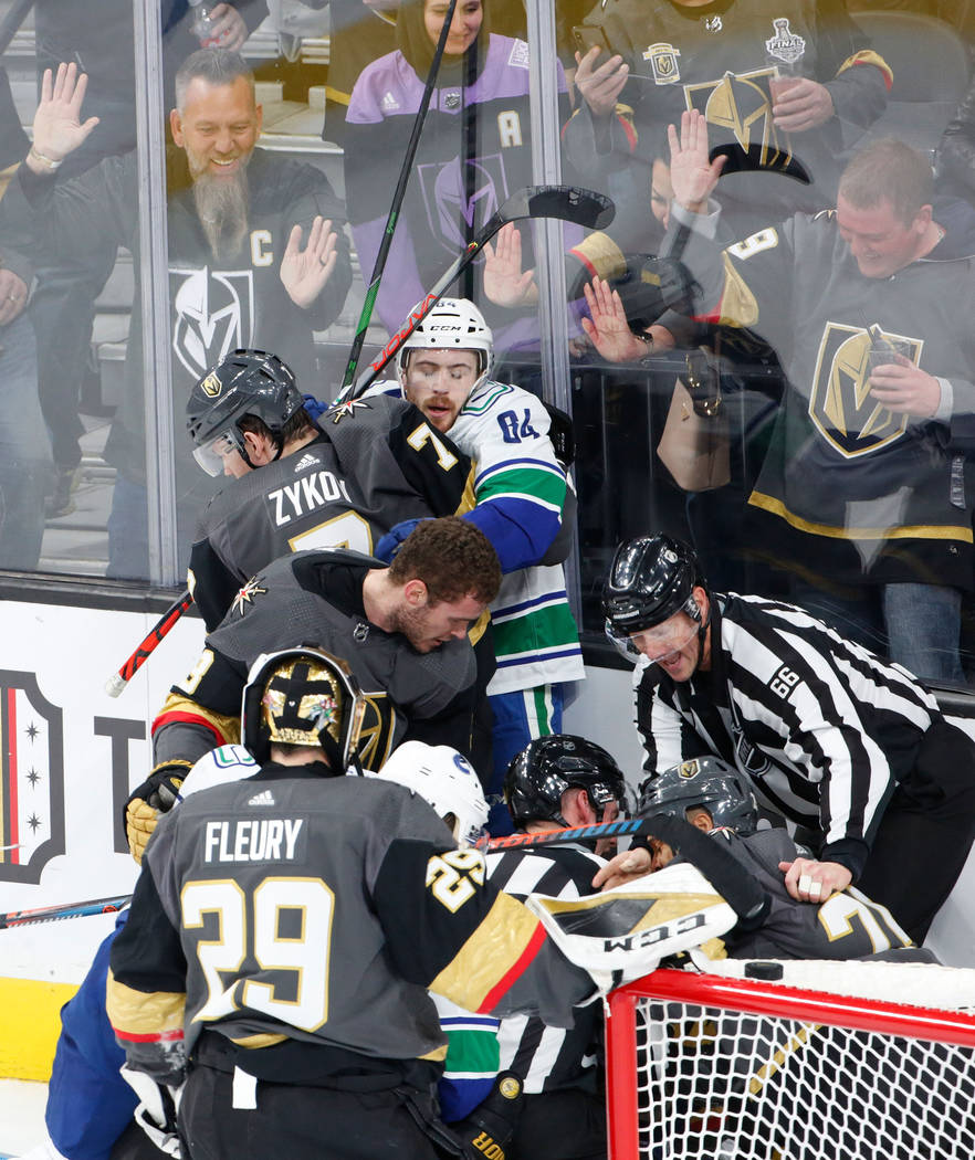Vegas Golden Knights left wing Valentin Zykov (7), left top, fights with Vancouver Canucks cent ...
